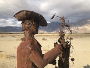 Steel sculpture of a man tending a grapevine.